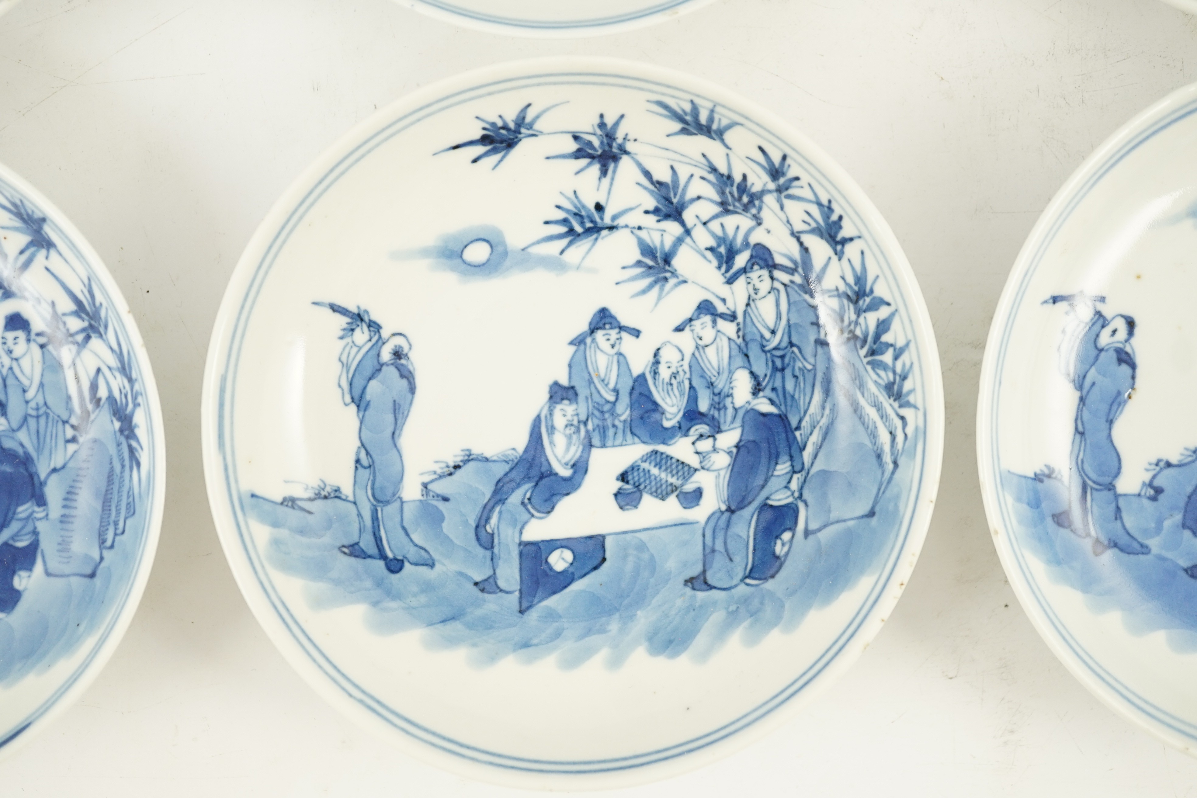 A set of six Chinese ‘Seven Sages of the Bamboo Grove’ saucer dishes, Kangxi marks but late 19th century, 12.3cm diameter